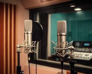防音ブースに設置されたNeumann U87とAKG C414のコンデンサーマイク